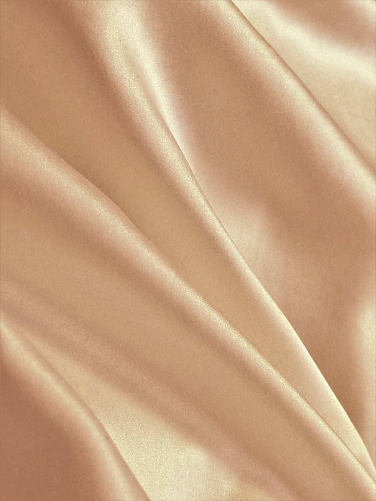 Tela de seda color caramelo con pliegues suaves y brillo natural