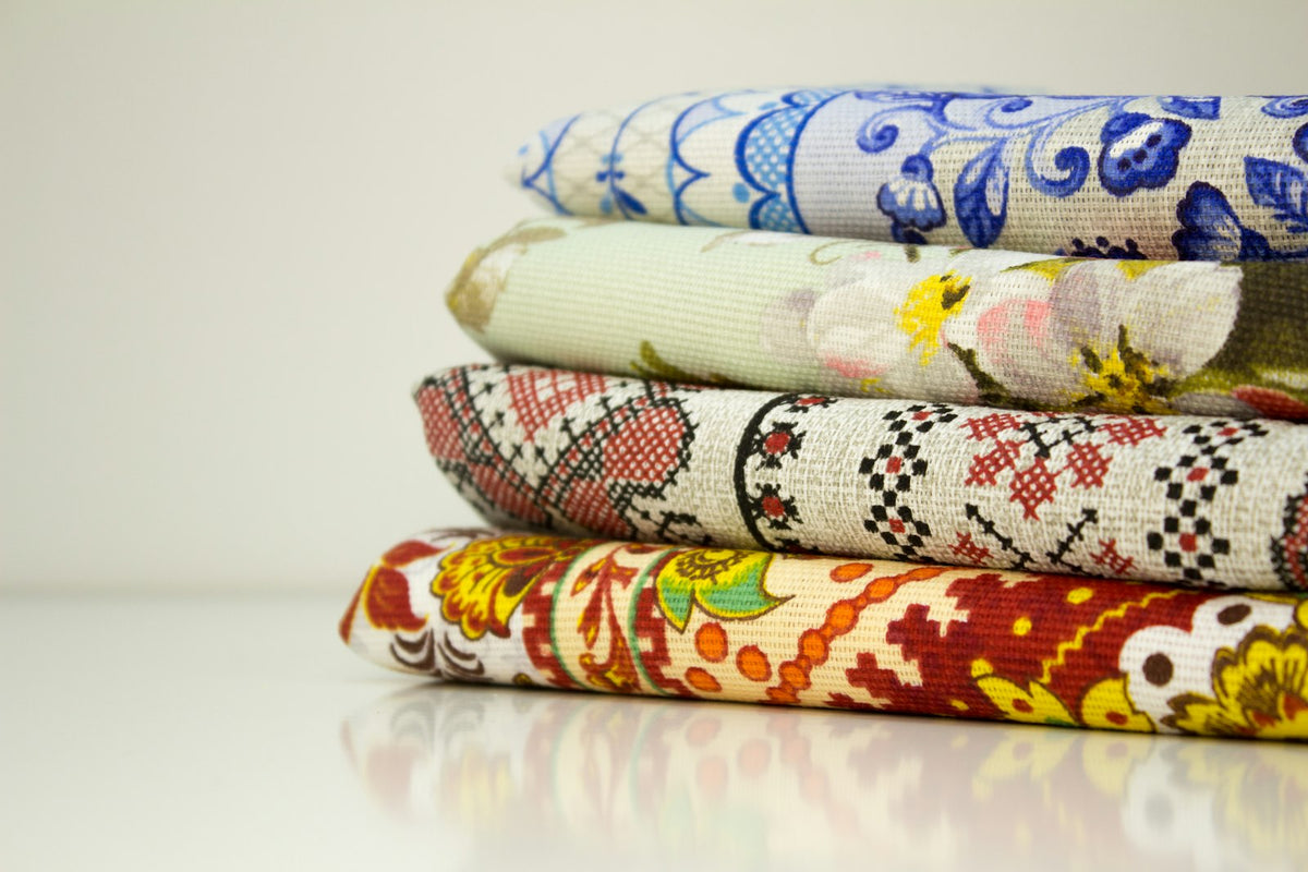 Pila de telas de algodón estampadas, dobladas sobre una superficie clara